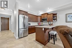 Kitchen featuring appliances with stainless steel finishes, a kitchen breakfast bar, crown molding, a peninsula, and open shelves - 