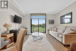 Living area with crown molding, light wood-style floors, and expansive windows - 