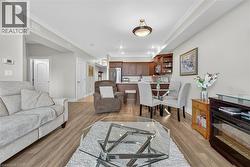 Living room featuring crown molding and light wood finished floors - 