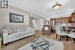 Living room with crown molding and light wood-style flooring - 