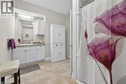Full bath featuring vanity and light tile patterned floors - 