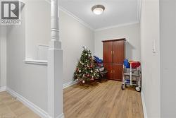 Hall with crown molding and light wood finished floors - 