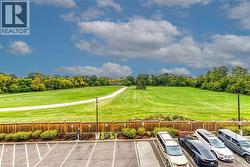 View of home's community with view of wooded area and uncovered parking - 