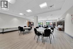Dining area with a paneled ceiling and light wood-style flooring - 