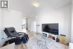 Living room with light wood-type flooring and baseboards - 