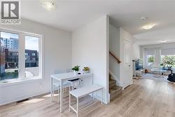 Dining area with light wood-style flooring and stairs - 