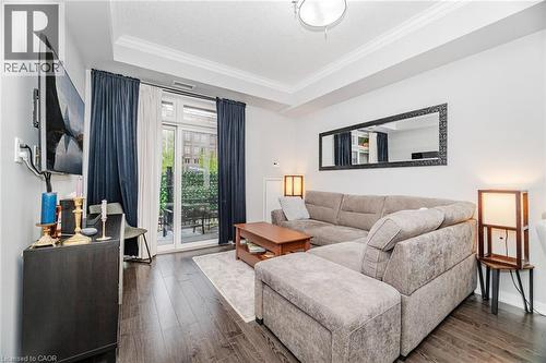 Living area with a tray ceiling, crown molding, and dark wood-type flooring - 5317 Upper Middle Road Unit# 112, Burlington, ON - Indoor Photo Showing Living Room