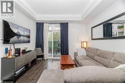Living room with wood finished floors, crown molding, and a raised ceiling - 