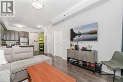 Living room featuring dark wood-type flooring, crown molding, and a textured ceiling - 