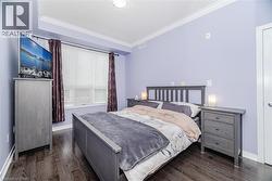 Bedroom with crown molding and dark wood-style flooring - 