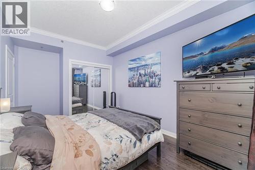 Bedroom with crown molding, dark wood-style floors, and a closet - 5317 Upper Middle Road Unit# 112, Burlington, ON - Indoor Photo Showing Bedroom