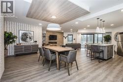 Dining area featuring light wood finished floors, wallpapered walls, a large fireplace, recessed lighting, and a skylight - 