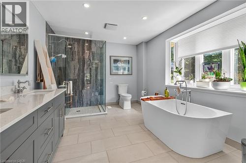 Bathroom with double vanity, a freestanding tub, a stall shower, light tile patterned floors, and recessed lighting - 5590 Blind Line, Burlington, ON - Indoor Photo Showing Bathroom