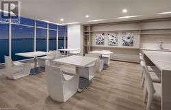 Dining room with a water view, light wood-style flooring, and recessed lighting - 