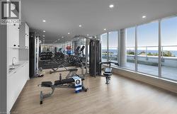 Gym with expansive windows, recessed lighting, and a water view - 