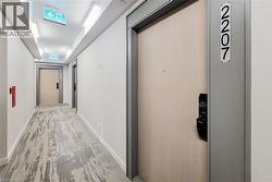 Corridor featuring baseboards and wood finished floors - 