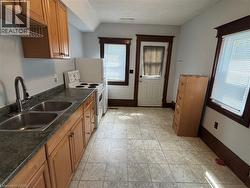 Kitchen with dark countertops, white electric range oven, and brown cabinets - 