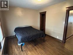 Bedroom with dark wood-style floors and a textured ceiling - 