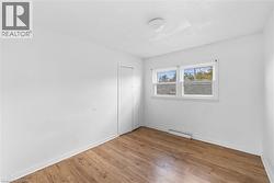 Unfurnished bedroom featuring wood-type flooring, a closet, and a textured ceiling - 