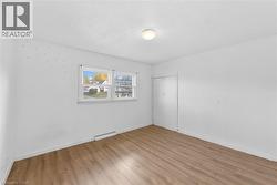 Unfurnished room featuring light wood-style floors and a textured ceiling - 