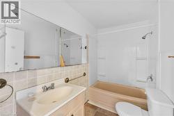 Bathroom with vanity, bathing tub / shower combination, tile walls, and tile patterned flooring - 