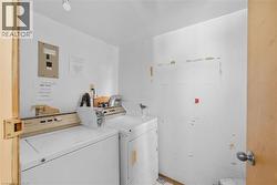 Shared laundry featuring electric panel and separate washer and dryer - 