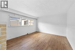 Empty room featuring a textured ceiling and wood finished floors - 