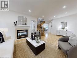 Living area featuring a multi sided fireplace, recessed lighting, arched walkways, light wood finished floors, and stairway - 