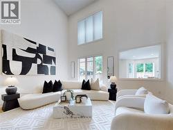 Living area featuring a towering ceiling and baseboards - 