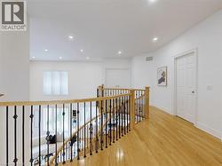 Hall featuring an upstairs landing, light wood-style flooring, and recessed lighting - 