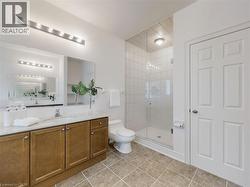 Bathroom featuring vanity, light tile patterned floors, and a shower stall - 