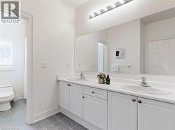 Bathroom with double vanity and light tile patterned flooring - 