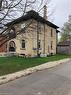 View of side of home featuring brick siding, a chimney, a yard, and a storage unit - 552 7Th Avenue, Hanover, ON  - Outdoor 