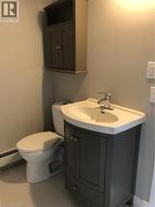 Half bathroom with vanity, a baseboard radiator, and tile patterned floors - 