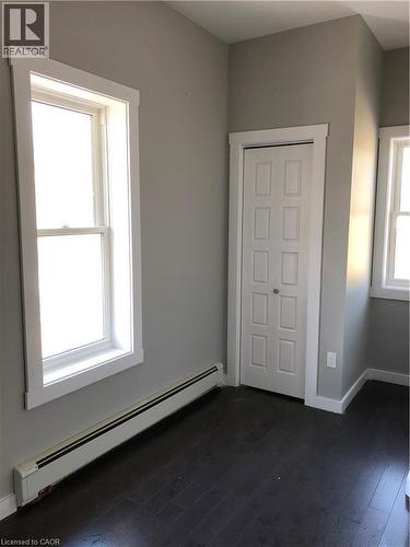 Unfurnished bedroom featuring a baseboard radiator and dark wood finished floors - 552 7Th Avenue, Hanover, ON - Indoor Photo Showing Other Room