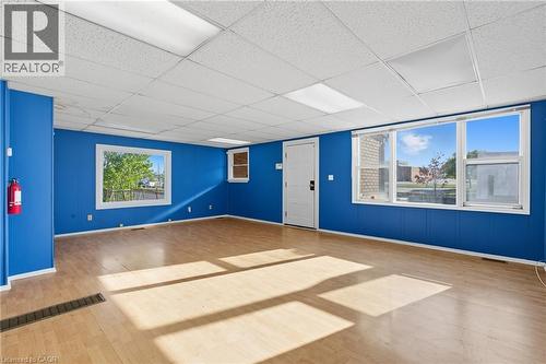 Empty room featuring wood finished floors, healthy amount of natural light, and a drop ceiling - 1036 Upper Wentworth Street, Hamilton, ON 