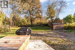 View of green lawn featuring an outdoor structure and a patio - 