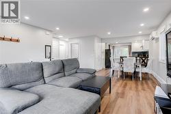 Living room with light wood-type flooring, recessed lighting, and a wall mounted air conditioner - 
