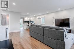 Living room featuring light wood-style floors, recessed lighting, and a wall mounted AC - 