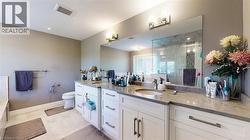 Bathroom with double vanity, a shower stall, and light tile patterned floors - 