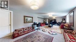 Carpeted living area featuring a textured ceiling and an office area - 