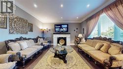 Living room featuring ornamental molding, dark wood finished floors, recessed lighting, and a fireplace - 