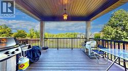 Deck featuring area for grilling, view of scattered trees, and outdoor dining space - 
