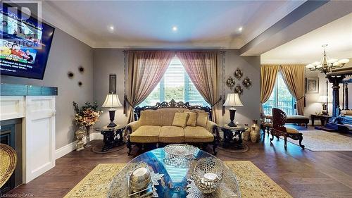 Living area featuring a chandelier, wood finished floors, crown molding, a fireplace, and recessed lighting - 537 Millstream Drive, Waterloo, ON - Indoor Photo Showing Living Room With Fireplace