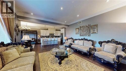 Living area featuring a chandelier, crown molding, dark wood finished floors, and recessed lighting - 537 Millstream Drive, Waterloo, ON - Indoor Photo Showing Living Room