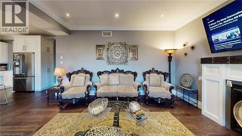 Living area with ornamental molding, recessed lighting, dark wood-type flooring, and a fireplace - 537 Millstream Drive, Waterloo, ON - Indoor Photo Showing Living Room With Fireplace