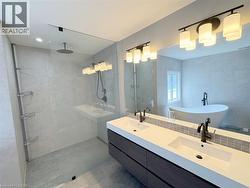 Bathroom featuring walk in shower, double vanity, a soaking tub, and tasteful backsplash - 