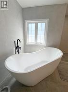 Full bathroom with a freestanding tub and tile walls - 