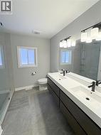 Full bathroom featuring walk in shower, double vanity, and plenty of natural light - 