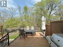 Wooden terrace featuring grilling area and outdoor dining space - 